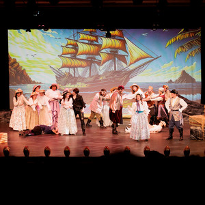 A stage filled with a large audience watching a performance