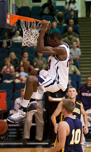 Ishmael hangs on the rim during dbu basketball game