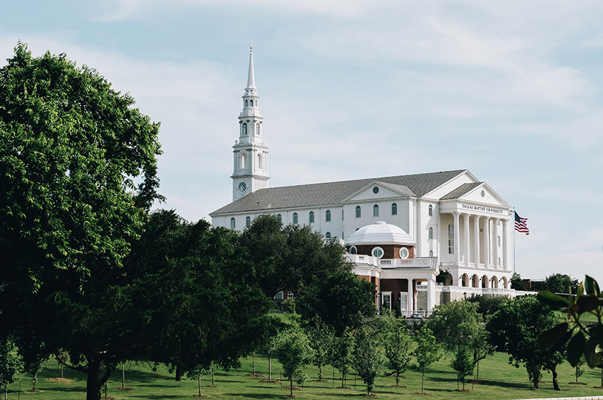 Christian University in Texas: DBU campus with trees near the chapel with flag in Dallas, Texas
