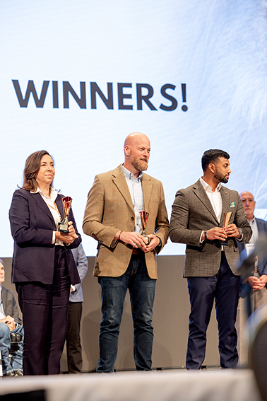 three winners stand with awards
